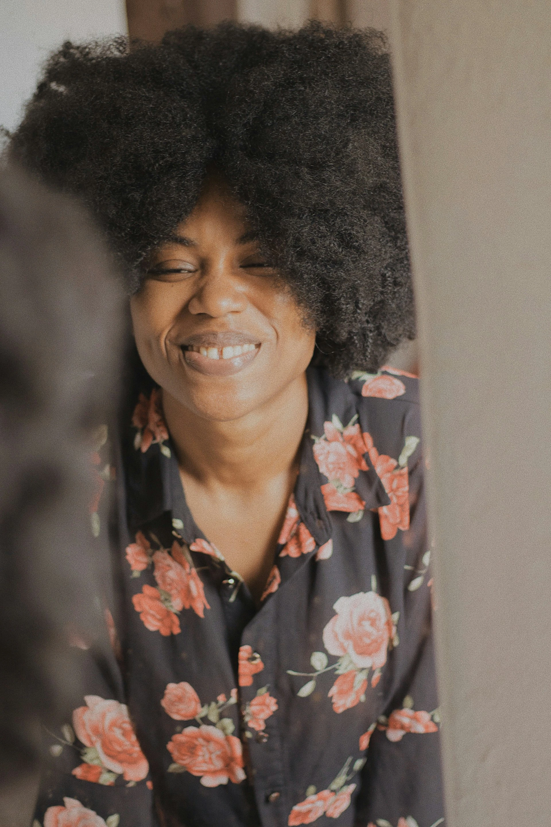 Donkere vrouw die lachend in de spiegel kijkt